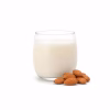 Verre de lait d'amande et amandes entières sur fond blanc