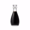 Flacon en verre de vinaigre balsamique brun foncé sur fond blanc