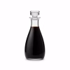Flacon en verre de vinaigre balsamique brun foncé sur fond blanc