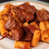 Assiette de macaronade rapide, rigatoni et morceaux de viande en sauce tomate
