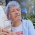 Le peintre Robert Combas tenant un grand coquillage contre son oreille