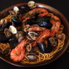 Spaghettis aux fruits de mer dans une poele avec moules palourdes et crevettes