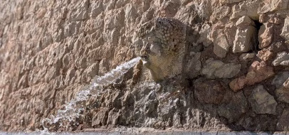 Mascaron en pierre crachant l'eau de la fontaine Saint-Maurice